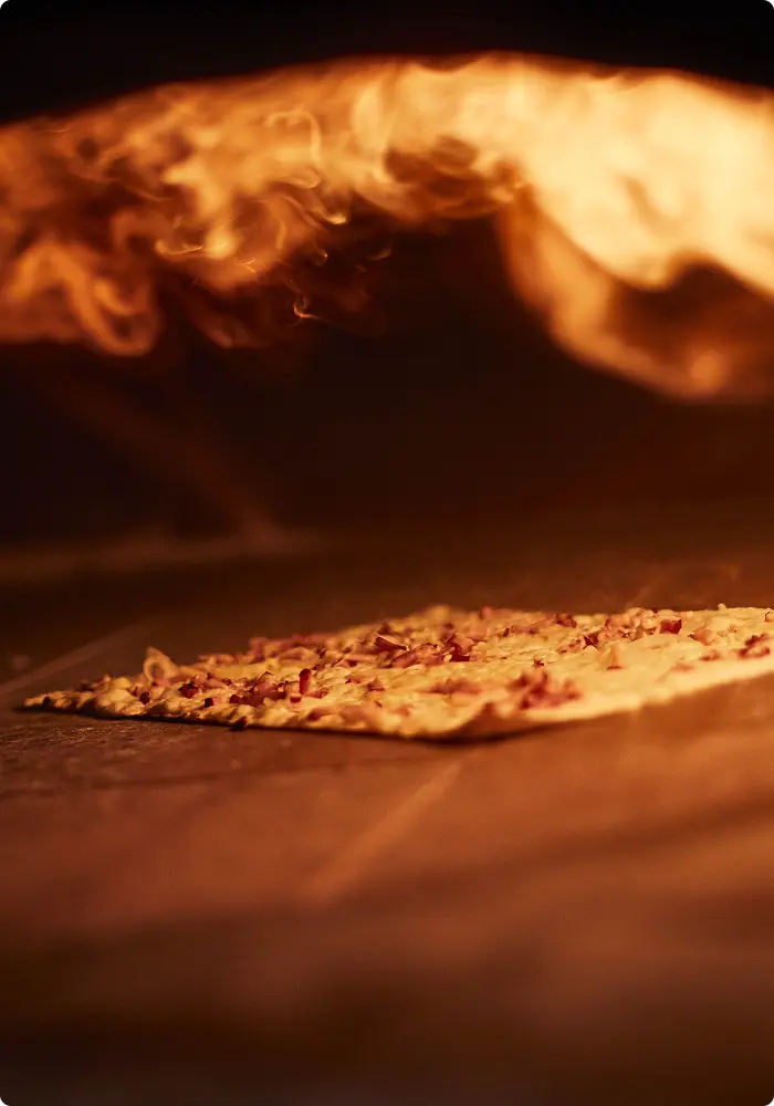 Flammekueche cuite au four à bois dans la cuisine du restaurant Meteor Marseille Vieux-Port.